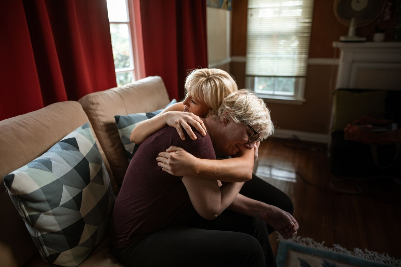 The Art of Drawing Readers In: Your attractive post title goes here An emotional and supportive embrace between a couple on a sofa, showcasing affection and togetherness in a cozy home setting.